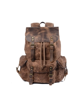 Detail of vintage canvas backpack with leather straps and front pockets in brown