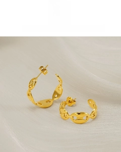 Detail of 18K vacuum plated gold link earrings on a white silk fabric background
