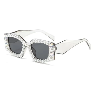 Lunettes de soleil polygonales avec perles blanches et strass colorés sur cadre clair