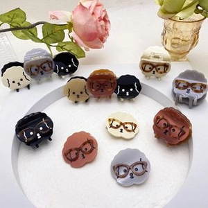Detailed view of cute dog-shaped hair clips with acetate finish and floral background