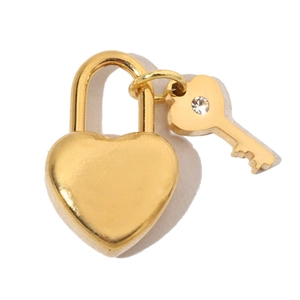 Close-up of golden heart-shaped padlock and a matching key with zircon detail
