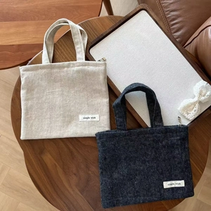 Minimalist cotton linen and denim tote bags with simple wish label on a wood table