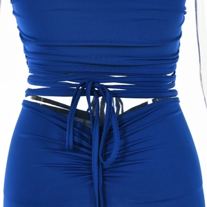 Détail de la tenue bleu marine montrant la taille lacée et la texture du tissu froncé