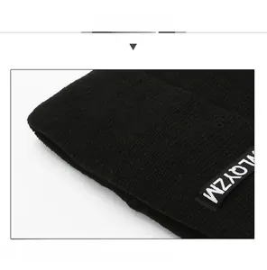 Close-up of black knit beanie fabric showing detailed texture and LQYZM woven label