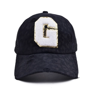 Detail of glitter G patch on black leopard pattern mesh baseball cap with frayed edges