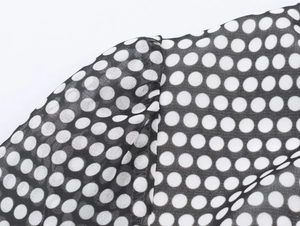 Close-up of shoulder seam and polka dot chiffon fabric on black vintage dress