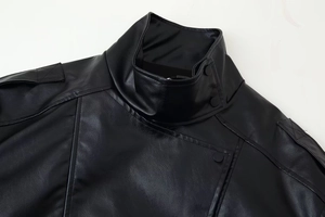 Detail view of stand collar, quilted shoulder patches and snaps on black faux leather jacket