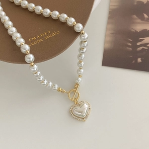 Macro detail of French vintage pearl heart necklace with rhinestones and OT buckle