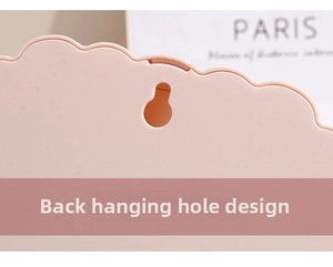 Detail view of the wall-mounting hole on back of a pink foldable desktop makeup mirror
