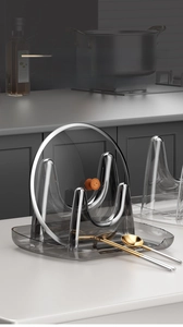 Detail of grey kitchen pot lid holder with drip tray for utensils and soup spoons