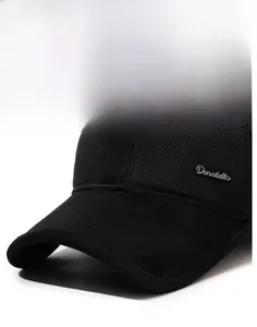 Detail of black winter baseball cap with silver Donatello metal tag and textured fabric
