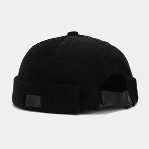 Detail view of black corduroy docker hat with vintage texture and adjustable leather strap