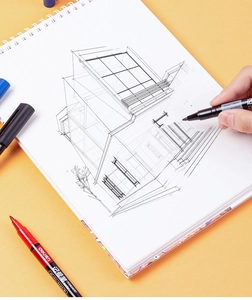 Detail of dual-tip permanent marker drawing architectural sketches on a notebook