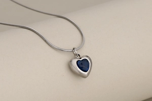 Detail of blue heart-shaped crystal pendant on silver stainless steel snake chain