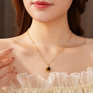 Detail of tiger eye stone pendant necklace worn by a model in warm artistic lighting