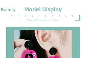 Close-up of oversized Halloween acrylic earrings with spider web and skull patterns