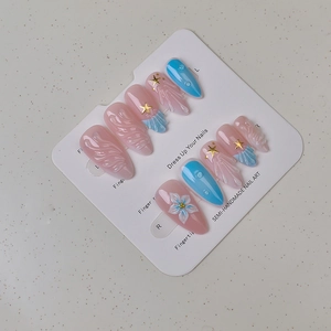 Detailed view of 3D shell and starfish press-on nails with 3D water droplets on display card