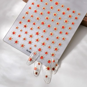 Detail of gold star nail art stickers with red gems and 3D application on clear nails