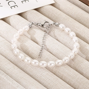 Detail view of pearl bracelet with silver heart charm and adjustable lobster clasp closure