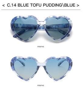 Close-up of heart-shaped sunglasses with marble pattern frame and gradient blue lenses