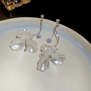 Vue macro des boucles d'oreilles fleur en perle argentée sur assiette en céramique