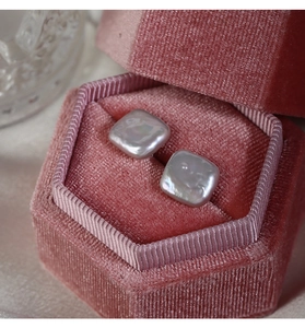 Macro shot of square baroque pearls in a pink velvet jewelry box with silk texture