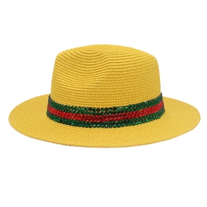 Détail d'un chapeau Panama jaune avec texture tissée et ruban de strass vert-rouge-vert