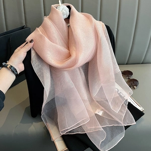 Close-up of pink silk scarf with gold thread detail on camellia floral hanger
