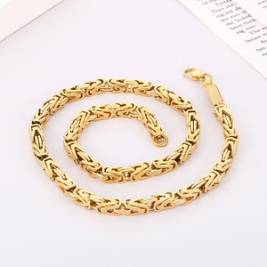 Macro detail of golden Byzantine chain necklace with polished finish on white background