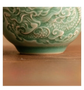 Macro shot of polished non-slip base on celadon ceramic teacup with dragon scales