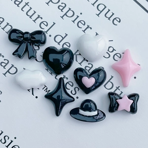 Macro shot of resin bow and heart charms for DIY crafts and nail art decoration