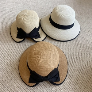 Tres sombreros de paja beige y marrón con cintas negras y tejido de paja detallado