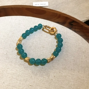Pulsera de cuentas de piedra natural verde azulado con detalles dorados y cierre