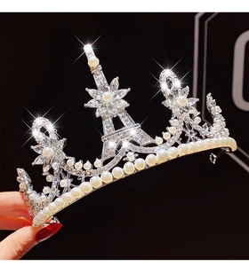 Detailed side view of silver princess crown with Eiffel Tower motif, pearls and crystals