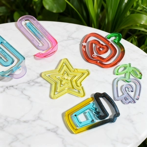 Detailed view of colorful acrylic paper clips in star, heart, and bottle shapes