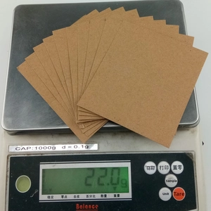 Digital scale showing a 22g weight measurement for thick brown cardboard postcard inserts