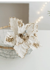 Detail view of velvet poinsettia with gold glitter petals and silver decorative balls