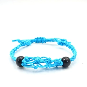 Detailed view of royal blue braided rope necklace with adjustable knots and black beads