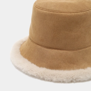 Close-up of winter bucket hat showing camel suede and white faux fur plush texture