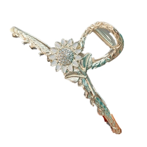 Dettaglio della molletta per capelli a girasole dorato con strass e petali bianchi