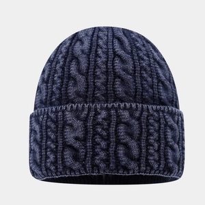 Détail de la maille torsadée bleu marine sur un bonnet d'hiver chaud à bord replié