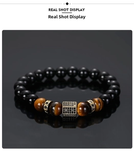 Macro shot of tiger eye beads and gold micro-pave cube spacer on a black men's bracelet