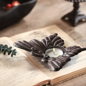 Vintage vlinder kandelaar van gietijzer op oude boeken voor rustieke decoratie