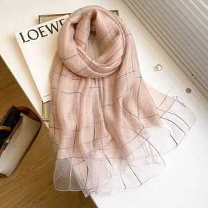 Pink striped silk wool scarf displayed on white table with fashionable magazines