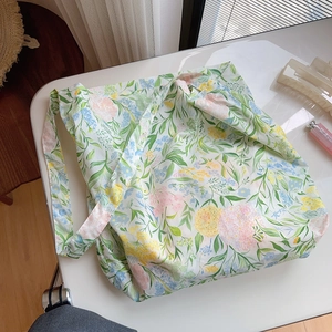 Detailed top view of a large cotton tote bag with a floral print and daily accessories