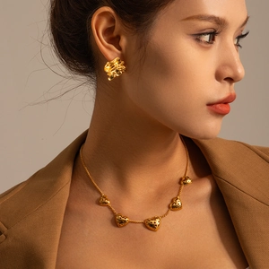 Detail of model wearing vintage golden textured rectangle earrings and matching necklace