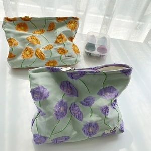 Detailed embroidery of Calla Lily on soft fabric cosmetic pouch with brand label