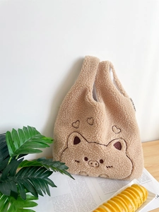Close-up of cute embroidered pig design on beige plush fleece wristlet handbag