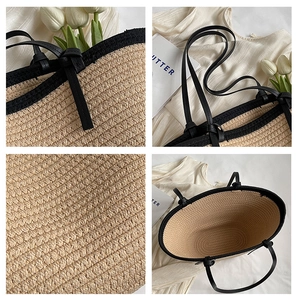 Close-up of woven straw tote bag with black leather straps and detailed texture