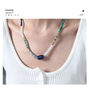 Close-up of handmade natural stone necklace with multi-color beads on a female model